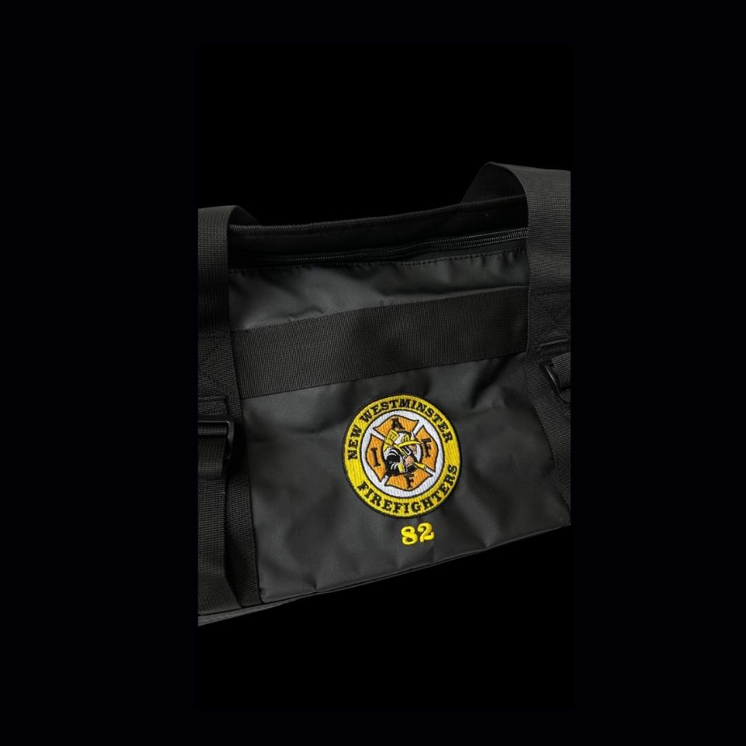 Black duffle bag with the New Westminster Firefighters' crest. Indicates that Zone West can customize bags & accessories.